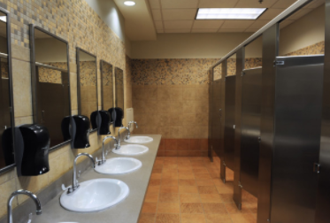Finished commercial restroom with sinks, tile and restrooms stalls. 